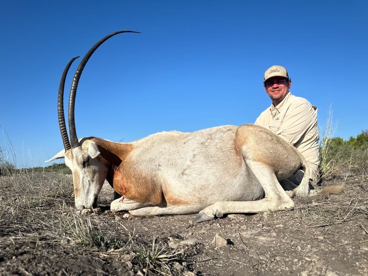 A hunter in the field with an oryx trophy